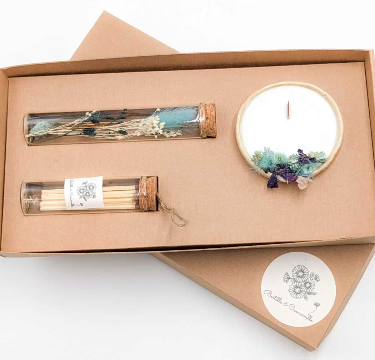 Coffret cadeau avec bougie en fleurs séchées parfumée eucalyptus orange, fioles d'allumettes et éprouvette de fleurs séchées aux couleurs bleu, le tout dans une jolie boîte en kraft.