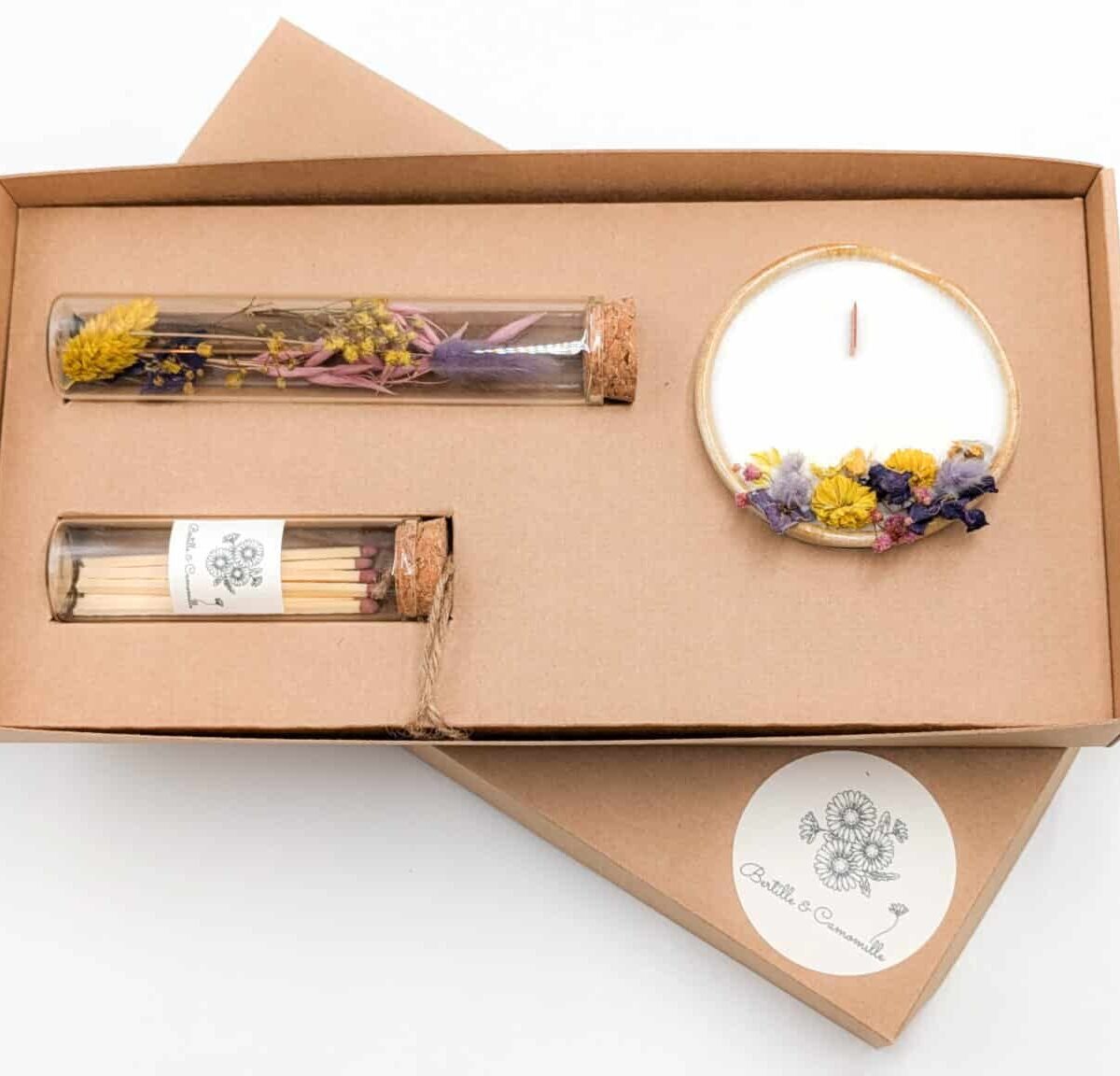 Coffret cadeau avec bougie en fleurs séchées parfumée à la violette, fioles d'allumettes et éprouvette de fleurs séchées aux couleurs violettes, le tout dans une jolie boîte en kraft.