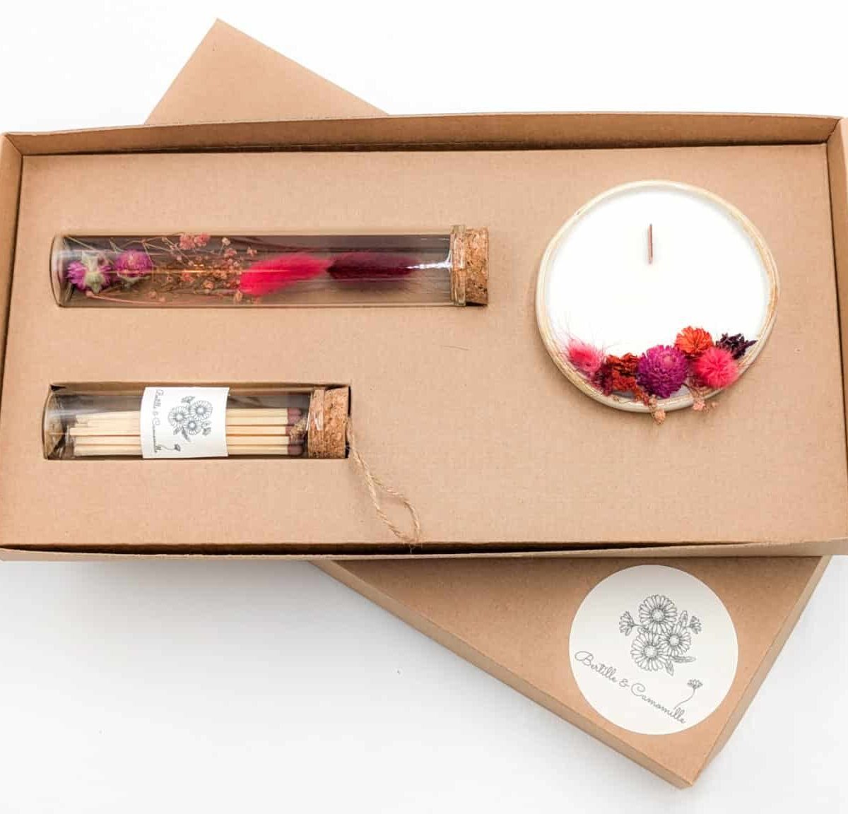 Coffret cadeau avec bougie en fleurs séchées parfumée cerise, fioles d'allumettes et éprouvette de fleurs séchées aux couleurs rouges, le tout dans une jolie boîte en kraft.