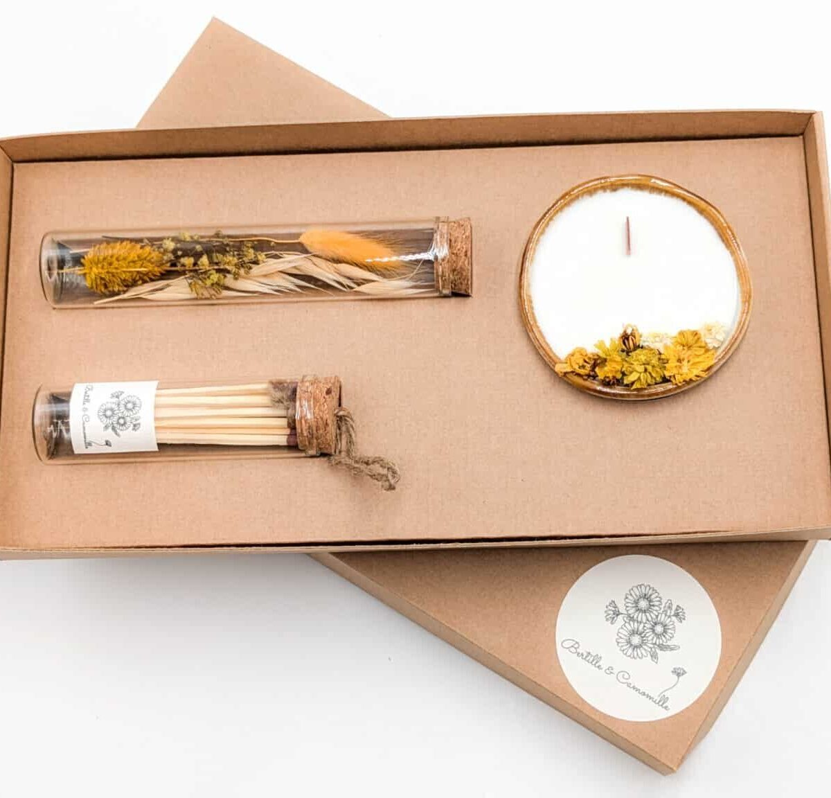 Coffret cadeau avec bougie en fleurs séchées parfumée à la vanille, fioles d'allumettes et éprouvette de fleurs séchées aux couleurs vanille, le tout dans une jolie boîte en kraft.